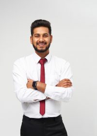 Portrait of young indian top manager in t-shirt and tie crossed arms and smiling on white isolated background